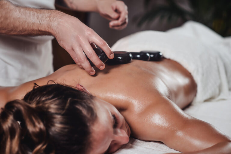 Thaimassage Stuttgart - Hot Stone Massage - Frau hat heiße Steine auf dem Rücken
